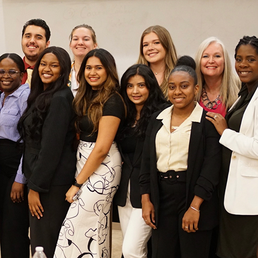 A group of smiling students pose for an image during an event.