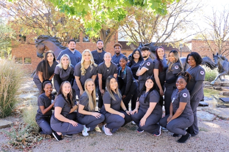 Respiratory students from the class of 2020 pose outside near the Spirit of the Mustangs statue.