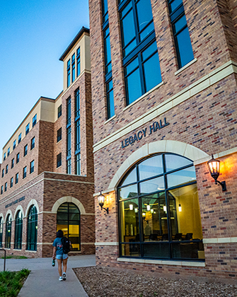 A student walks past Legacy Hall Residence Hall.