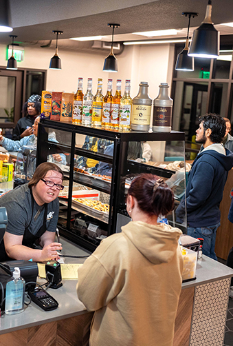 Several students gathered inside Campus Coffee while being helped by an employee at the counter.