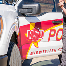MSU Texas Police office holds department truck door open, MSU Texas logo facing you