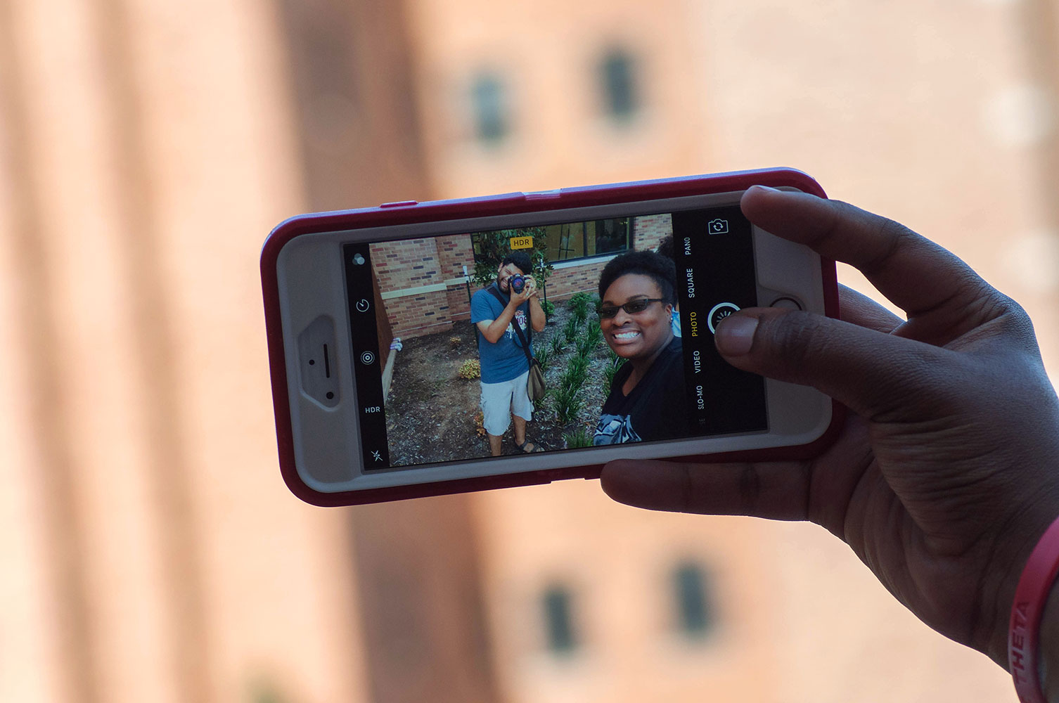 AJ selfie with a camera taking a picture of him in a phone