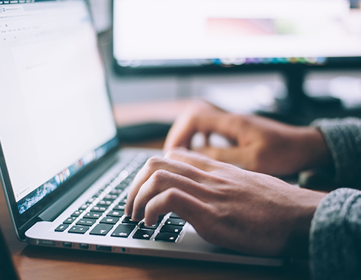 A student works on their laptop, typing a document.