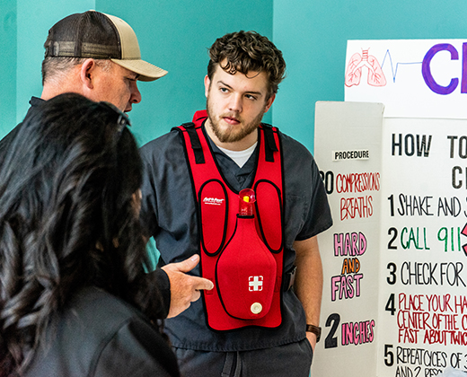A health sciences student speaks with visitors at his booth during a health fair event inside Centennial Hall.