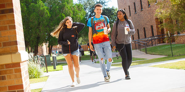 Three students walking on campus.